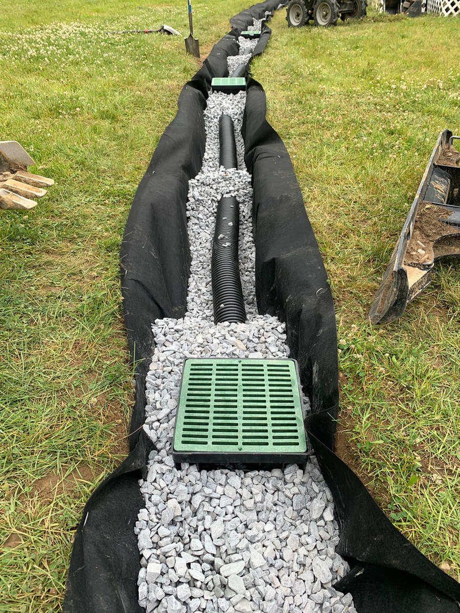 How to install a french drain idea picture. Drainage solution for water in the yard. Building a french drain with catch basins.  DIY french drain ideas for a yard or outside a house.  