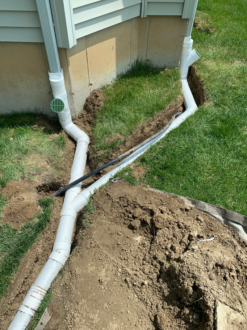 DIY drainage ideas for the exterior of a house, landscape, and yard. How to install underground drainage outside a home picture. Drainage solution to fix an outdoor water problem. Home improvement project idea for exterior basement waterproofing, landscaping, plumbing, and drainage systems. 