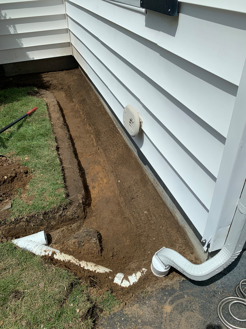 How to install drainage around the outside foundation of a home. DIY french drain system installation ideas with rock landscape bed. Burying gutter downspout pipe underground, making a french drain, and installing a catch basin discharge outlet in the yard pictures. Exterior basement waterproofing and drainage solutions to prevent water leaking into a house after it rains by diverting rainwater. How to make a french drain with buried downspout. Plumbing and landscaping idea for your home.