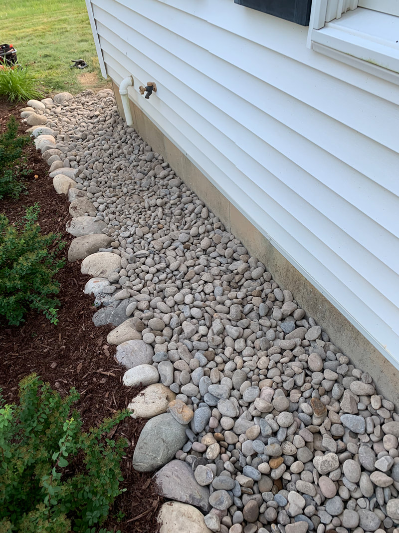 DIY drainage installation pictures for water outside a home. Exterior foundation french drain system and underground downspout drainage ideas. How to install a french drain stone landscape bed around a house and burying gutter downspout drain pipe. Drainage ideas for french drains, downspouts, catch basins, and plumbing pipes.